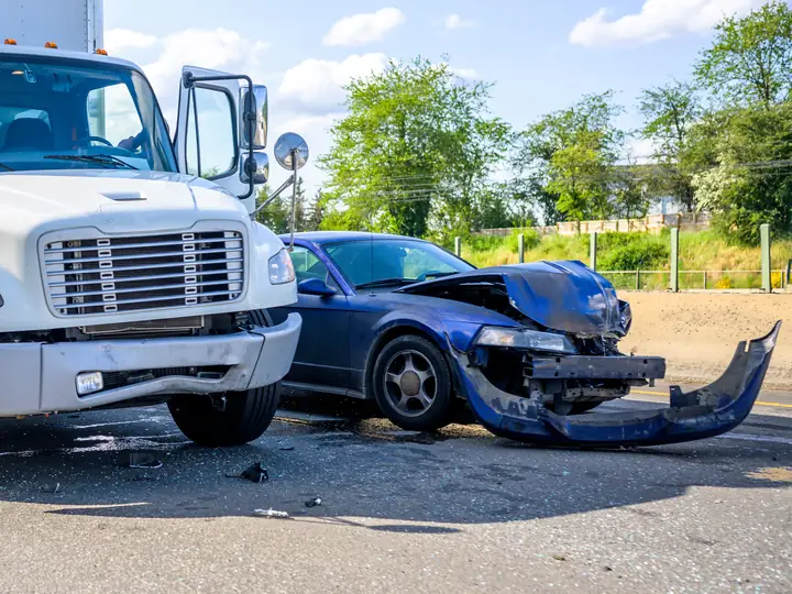 A box truck and a passenger car after a collision on a roadway
